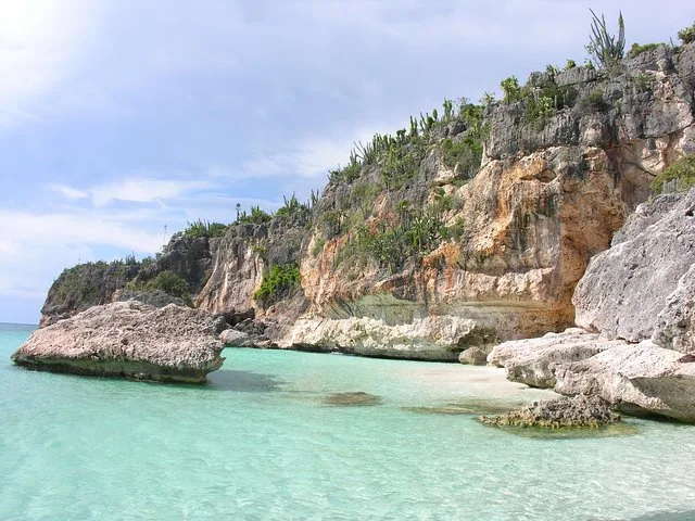Acantilados rocosos con cactus a lo largo de una costa impresionante de agua turquesa.